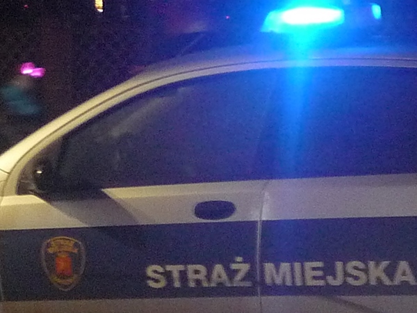 Zdjęcie ilustracyjne: radiowóz straży miejskiej z włączonymi światłami sygnalizacyjnymi